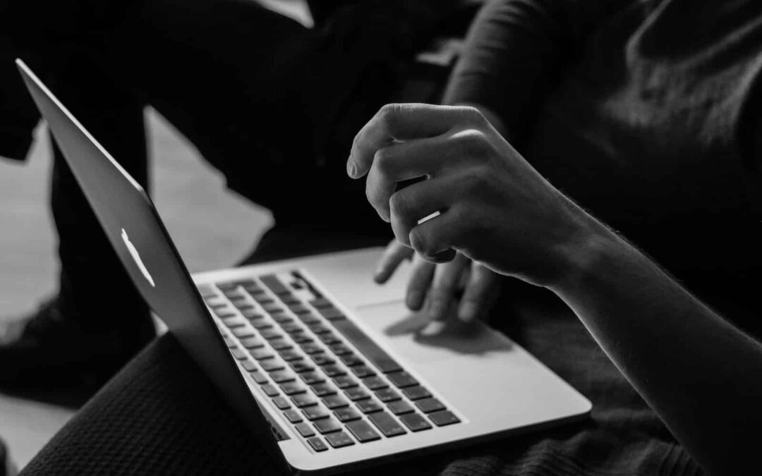 grayscale photo of person using MacBook