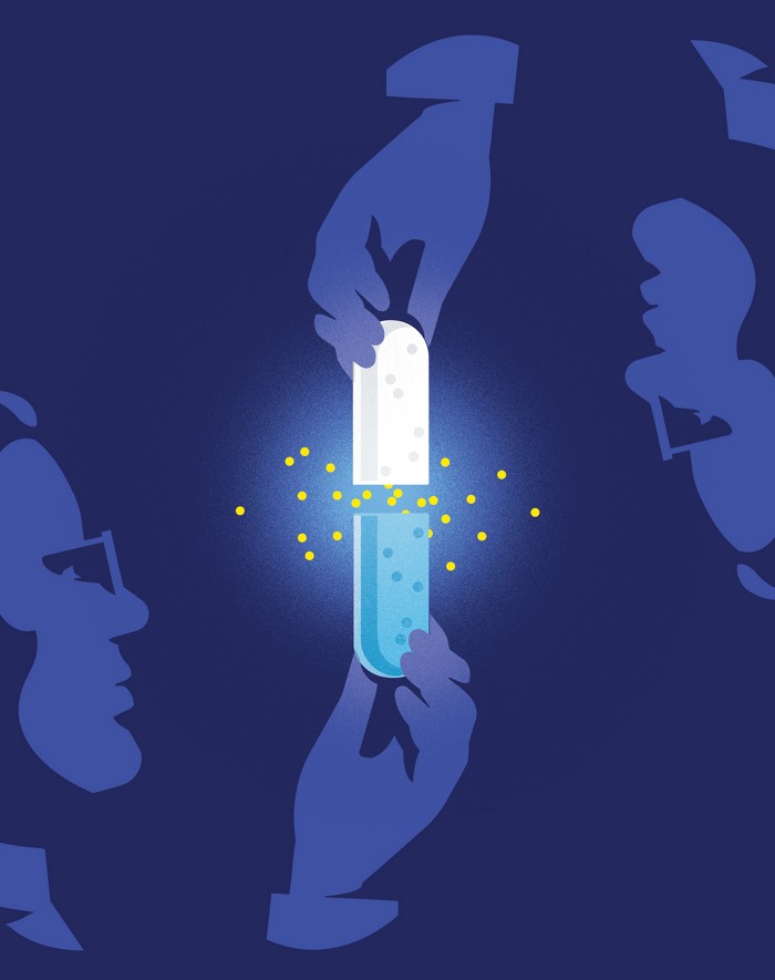 A mostly blue-hued illustration of someone in glasses holding an open capsule. A hand from above pulls on the other end of the capsule, which is white. Where the capsule is opened, yellow dots glow.