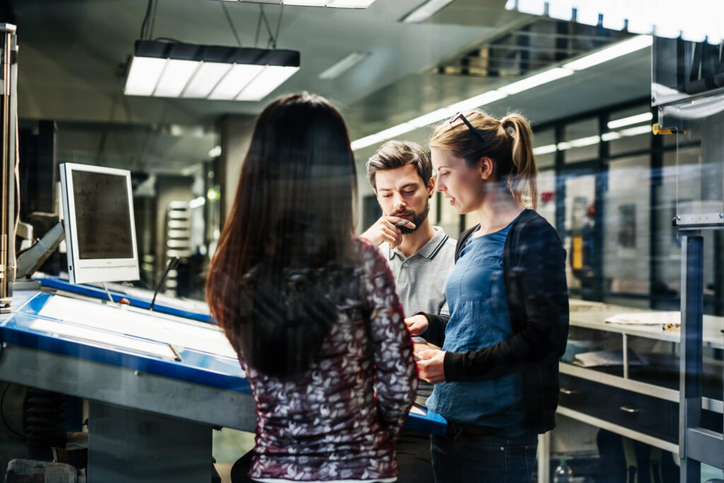 Printing Plant Engineers Working Together At Console